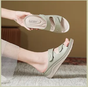 Detalle de sandalias de cuña verde claro con tiras pespunteadas y plantilla ergonómica