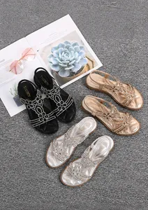 Detail of bohemian flat sandals with sparkling rhinestone flowers in black, gold, and silver