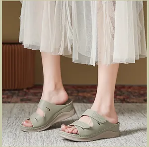 Detalle de sandalias de cuña verde salvia con costuras decorativas y suela gruesa