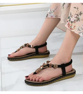 Close-up detail of Bohemian flat sandals featuring ethnic wood beads and flowers