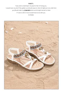 Détail de sandales compensées blanches avec perles bohèmes et breloque tournesol
