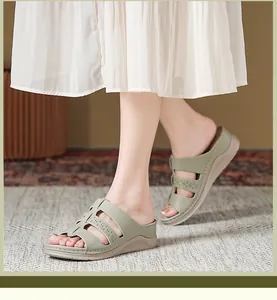 Detailweergave van saliegroene sleehak sandalen met bloemmotief en comfortabele dikke zool