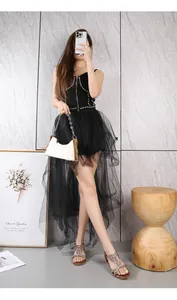 Detail of bohemian black mesh skirt with irregular layered design and punk rivet vest