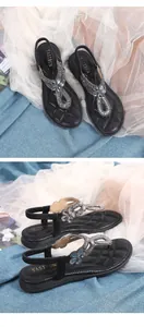 Nahaufnahme der Sandalen mit Strassblumen, T-Riemen und gesteppter Innensohle für Damen