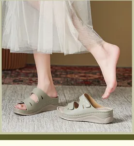 Detalle de sandalias con cuña verde oliva con costuras y cierre de velcro ajustable