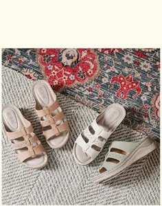 Detailweergave van dames sandalen met sleehak in roze, wit en groen met opengewerkte bandjes