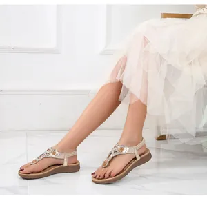 Λεπτομερής όψη από τα χρυσά boho σανδάλια με αστραφτερά στρας σε σχήμα ηλίανθου