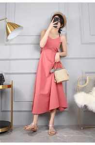 Dettaglio dei sandali piatti bohémien con strass e un elegante abito estivo rosa da donna