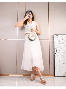Dettaglio di sandali argento con strass abbinati a gonna boho e gilet in maglia a polo