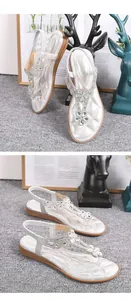 Détails de sandales plates argentées avec décor floral en cristal et bride élastique