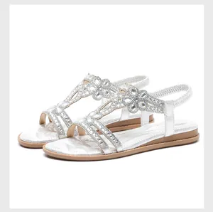 Detailed view of silver flat sandals with crystal rhinestone embellishments and elastic heel
