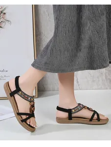 Close-up of bohemian flat sandals with colorful beads and elastic straps on model