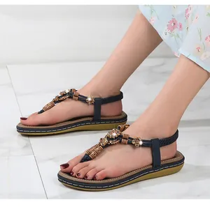 Detail of bohemian navy sandals with floral metal beads and rhinestones decoration