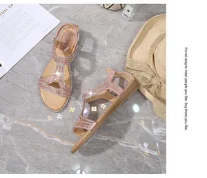 Dettaglio di sandali a T oro rosa con strass su marmo con accessori estivi