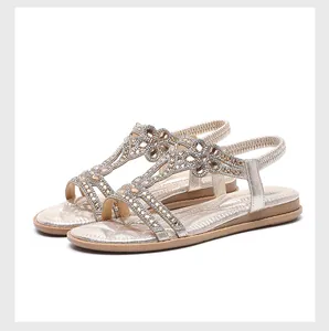 Detailed close-up of champagne gold sandals featuring floral rhinestone accents and T-strap
