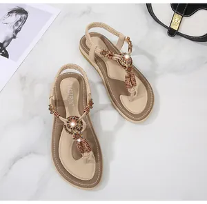Detail of bohemian flat sandals with braided flowers, vintage beads and rhinestones