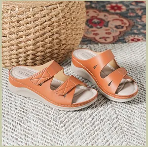 Detalle de sandalias de cuña marrones con costuras visibles y plantilla cómoda