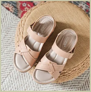 Detail von beigen Kreuzband-Sandalen mit Metallschnalle und weichem Fußbett für Komfort