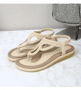 Détail de sandales tressées beige minimalistes sur marbre avec sac à main argenté