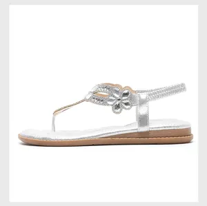 Detailansicht der Strassblume auf silbernen flachen Bohemian-Sandalen für Damen