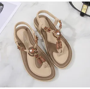 Detailed view of bohemian sandals with ethnic beads and elastic heel strap on marble surface