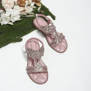 Detail of pink bohemian flat sandals with rhinestone floral patterns and quilted footbed