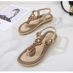 Detail of bohemian flat sandals featuring ethnic wooden beads and sparkling floral accents