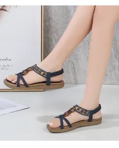 Detail of bohemian flat sandals featuring colorful beads and navy elastic straps