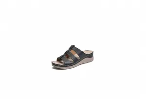 Detail van zwarte sleehak sandalen met decoratieve uitsnijdingen en witte stiksels op rand