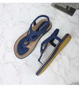 Détail de sandales plates tressées bleu marine avec bride arrière et semelle antidérapante