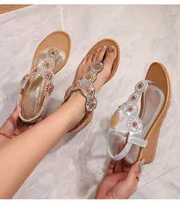 Dettaglio dei sandali con zeppa boho con strass scintillanti e cinturino a T floreale