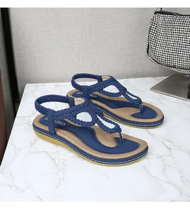 Détail de sandales tressées bleu foncé à bride en T avec bride arrière élastique