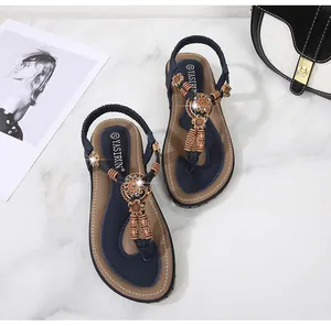 Flat bohemian navy blue sandals featuring sunflower rhinestone charms and wooden beads