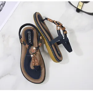 Detail of bohemian flat sandals featuring navy blue straps with vintage wooden beads