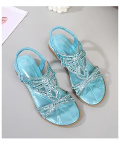 Detail of blue bohemian flat sandals with rhinestones, beads and elastic strap