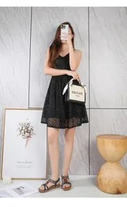 Detailed view of women's black lace V-neck dress paired with stylish flat beaded sandals