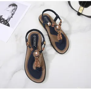 Macro detail of navy bohemian T-strap sandal with sunflower ornament and wood beads