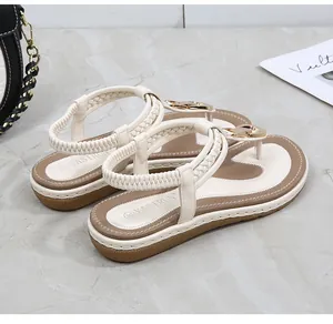Detail of t-strap sandal with gold buckle, woven elastic heel strap and branded footbed