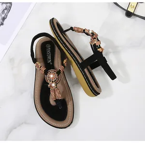 Detail of bohemian T-strap sandals with vintage floral beadwork and woven textures