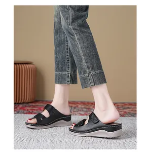 Sandalias de cuña negras puestas con correas de velcro y costuras blancas decorativas