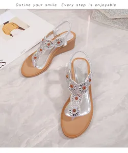 Dettaglio di sandali con zeppa bohémien argento con strass a forma di fiori di sole