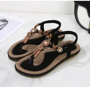 Detail of bohemian flat sandals with ethnic beads and crystal flower accents