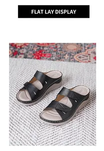 Detalle de sandalias de cuña negras con tiras dobles y costuras blancas en contraste