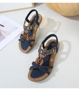Detail view of ethnic flat sandals with navy straps, colorful beads and wood rings