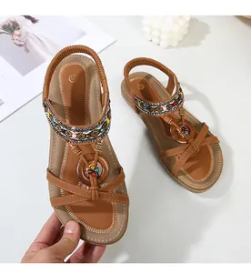 Detail of bohemian flat sandal with ethnic beads, woven straps and wooden buckle decoration