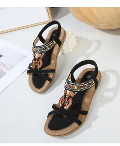Detail view of bohemian sandals with colorful beads, rhinestones and wooden rings decor