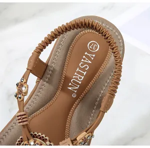 Detailed macro view of bohemian sandals featuring floral ornaments and branded insole