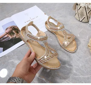 Dettagli di sandali dorati boho con strass scintillanti e design con cinturino a T