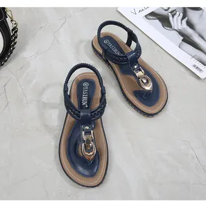 Detail of dark blue thong sandals with woven T-strap and golden buckle on marble floor