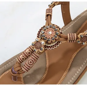 Detail of bohemian flat sandals with rhinestone flower charms and beaded weaving